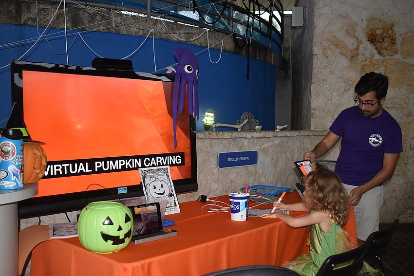 Aria Fischer makes her pumpkin come to life with the help of Ross Johnston.