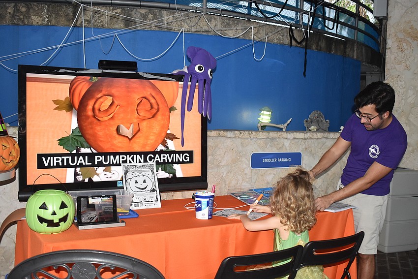 Aria Fischer makes her pumpkin come to life with the help of Ross Johnston.