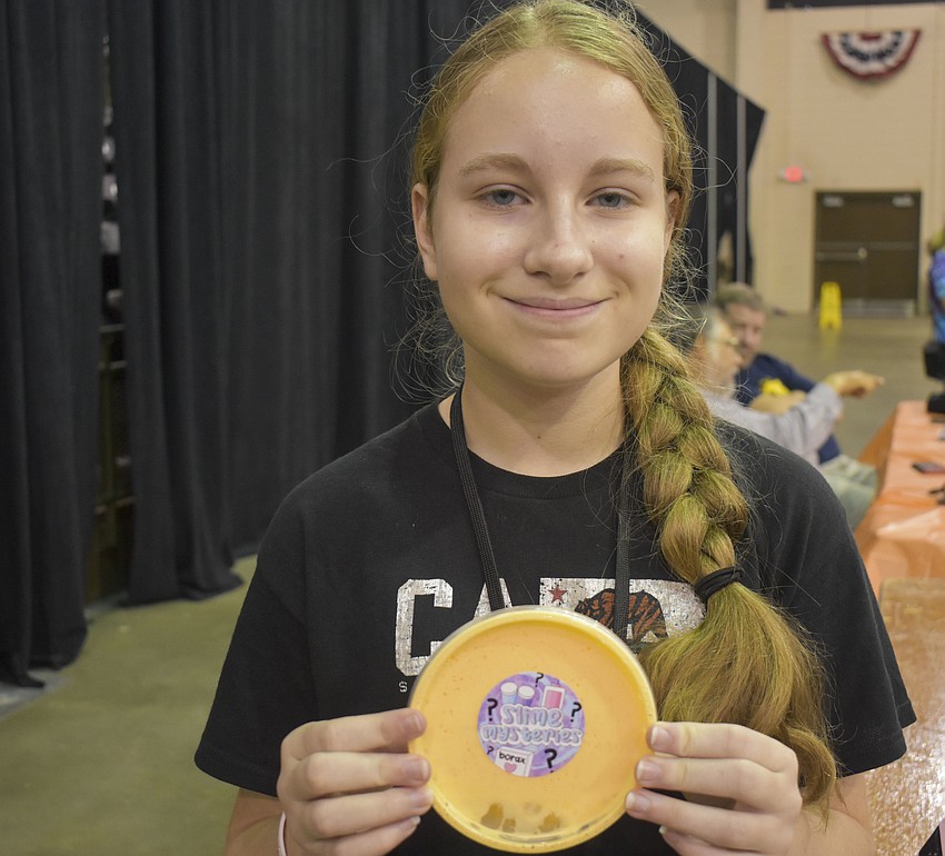 Kristina Burmeister waits in the slime trading center to share her homemade candy corn slime from Slime Mysteries.