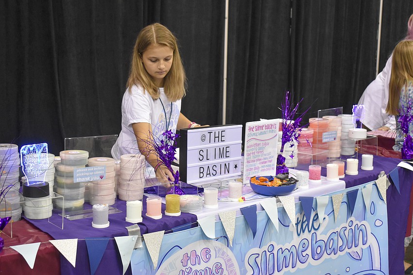 Madi Thomas, 13, fixes her booth.