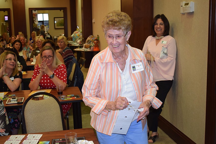 Bradenton's Nadine O'Connor hurries up to the front of the room to claim her designer purse after she yelled, 