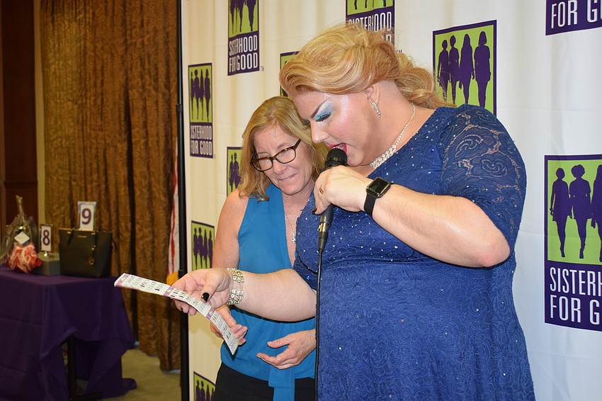 Kimi Newcomb, a Sisterhood for Good member, goes over her Bingo card with Beneva Fruitville after she won the third game.