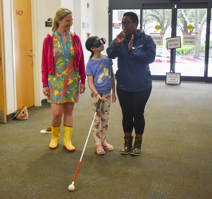 Daphne Silvestri, 8, and her mom Bonnie learn how to walk with a white cane from Latricia Gambrell.