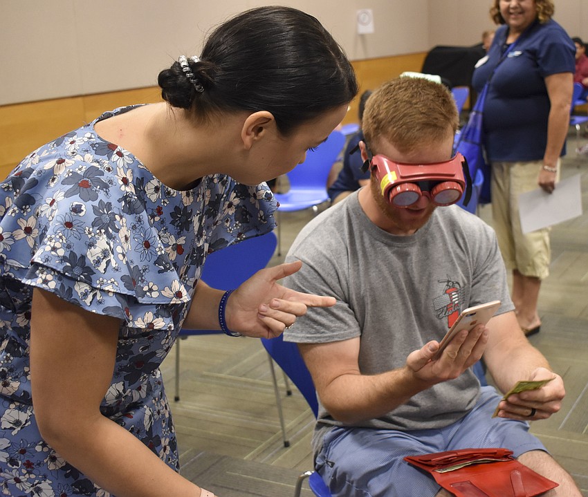 Olga Strelkova teaches Dan Spencer how to work a currency app.