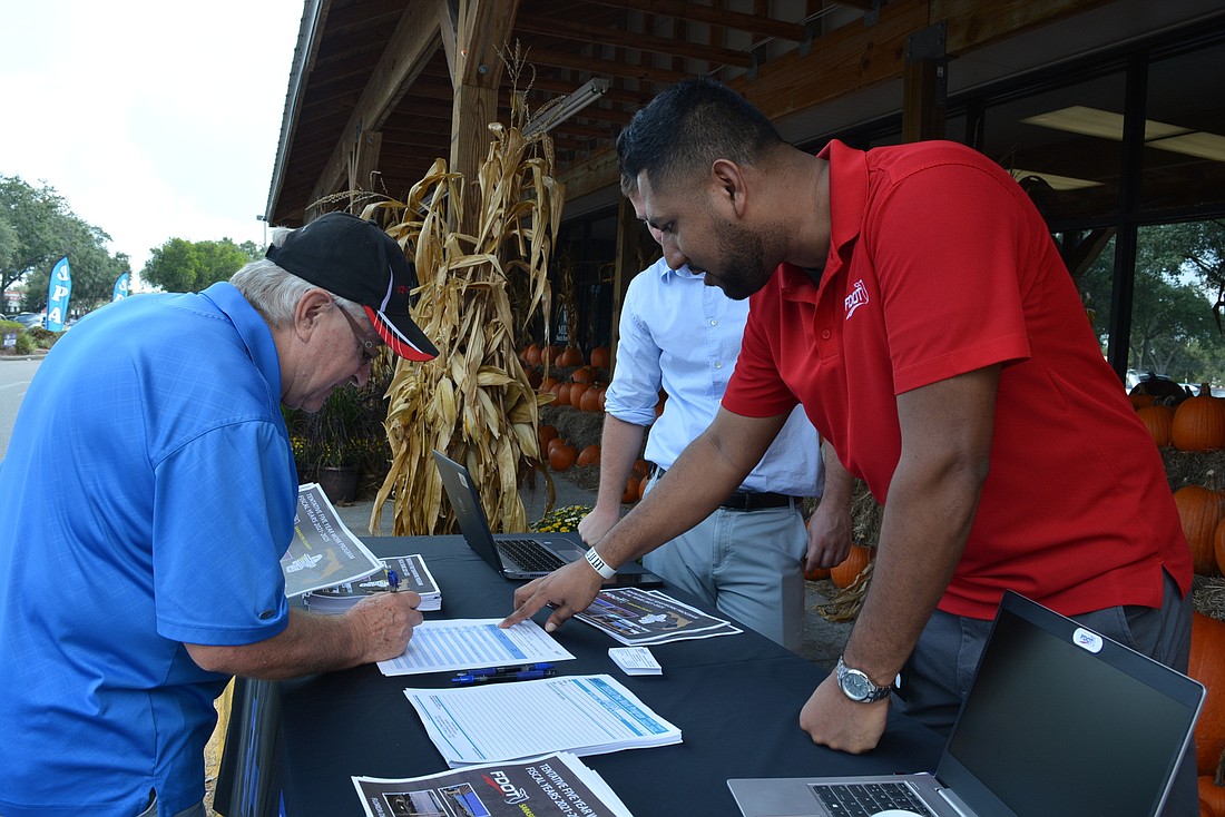 River Club resident Cas Bruniany signs up for information about Florida Department of Transportation&#39;s future plans during an e-public hearing Oct. 23 outside Detwiler&#39;s Farm Marker. FDOT&#39;s Dan Calais and Jesten Abraham were ready.