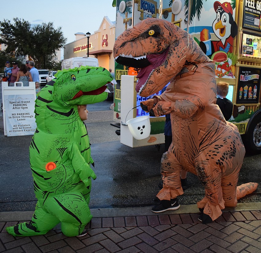 Sarasota resident Asa Wade, 5, and his dad, Stewart, march around Boo Fest as dinosaurs. Asa Wade loves being a dinosaur.