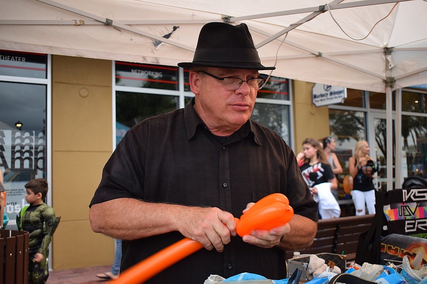 Mike Jones makes balloon pumpkins for Boo Fest attendees.