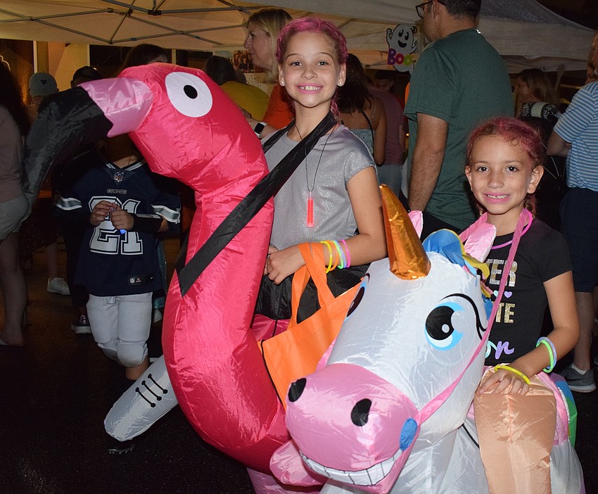 Lakewood Ranch's Emma Inboden, 9, dresses as a flamingo while Lake Wales' Kathryn Smith, 6, goes to Boo Fest as a unicorn.