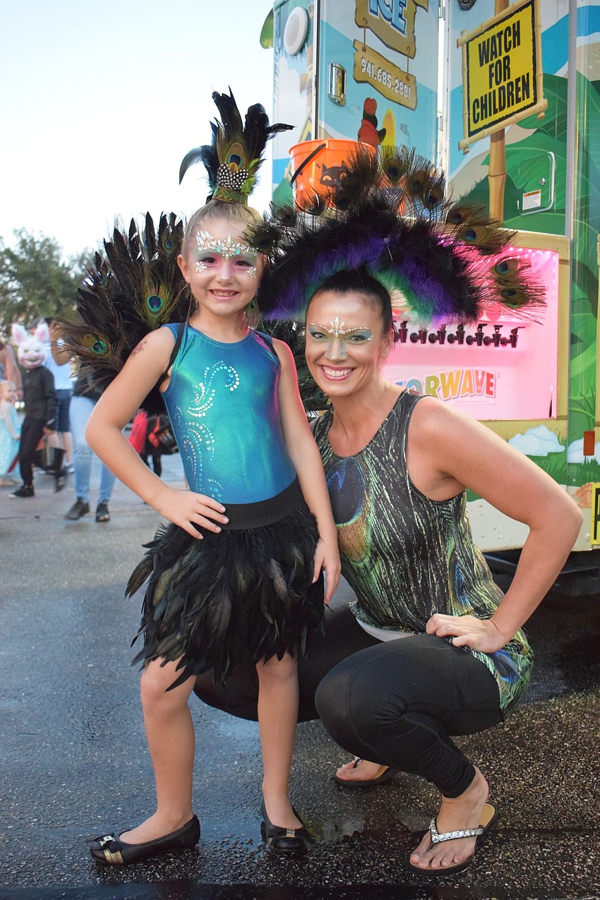Sarasota's Jadyn Wade, 7, and her mom, Sam, dressed as peacocks. Jadyn chose peacocks because she had to write a book report about them.