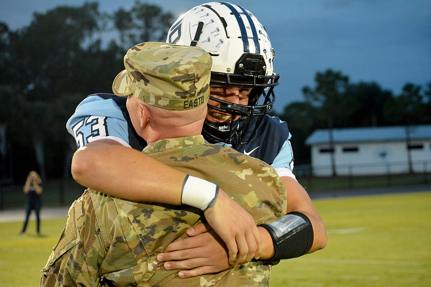 Senior J.J. Easto hugs his father, Captain Joshua Easto, who surprised him and sophomore brother Jackson Easto with a return home from duty.
