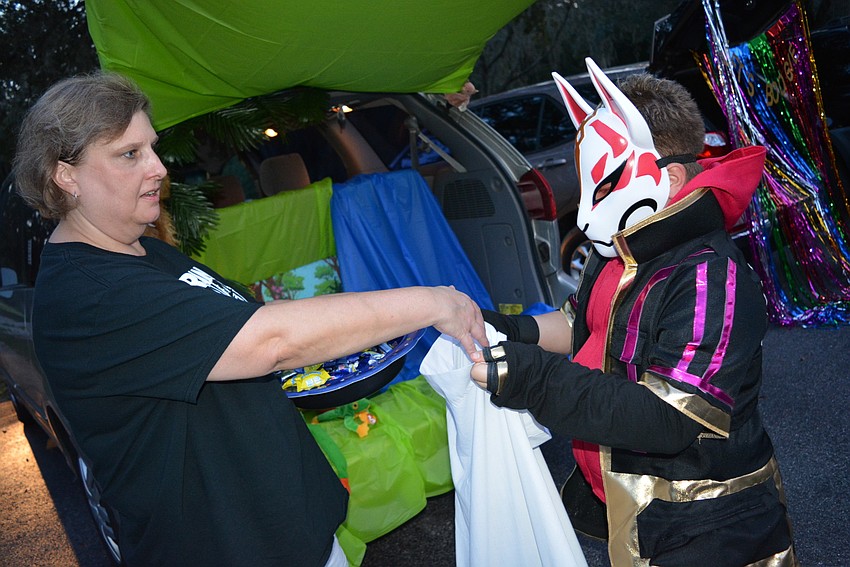Living Lord Lutheran Church Deacon Tara Friedrichs gives candy to 9-year-old Devin Sandford, dressed as 