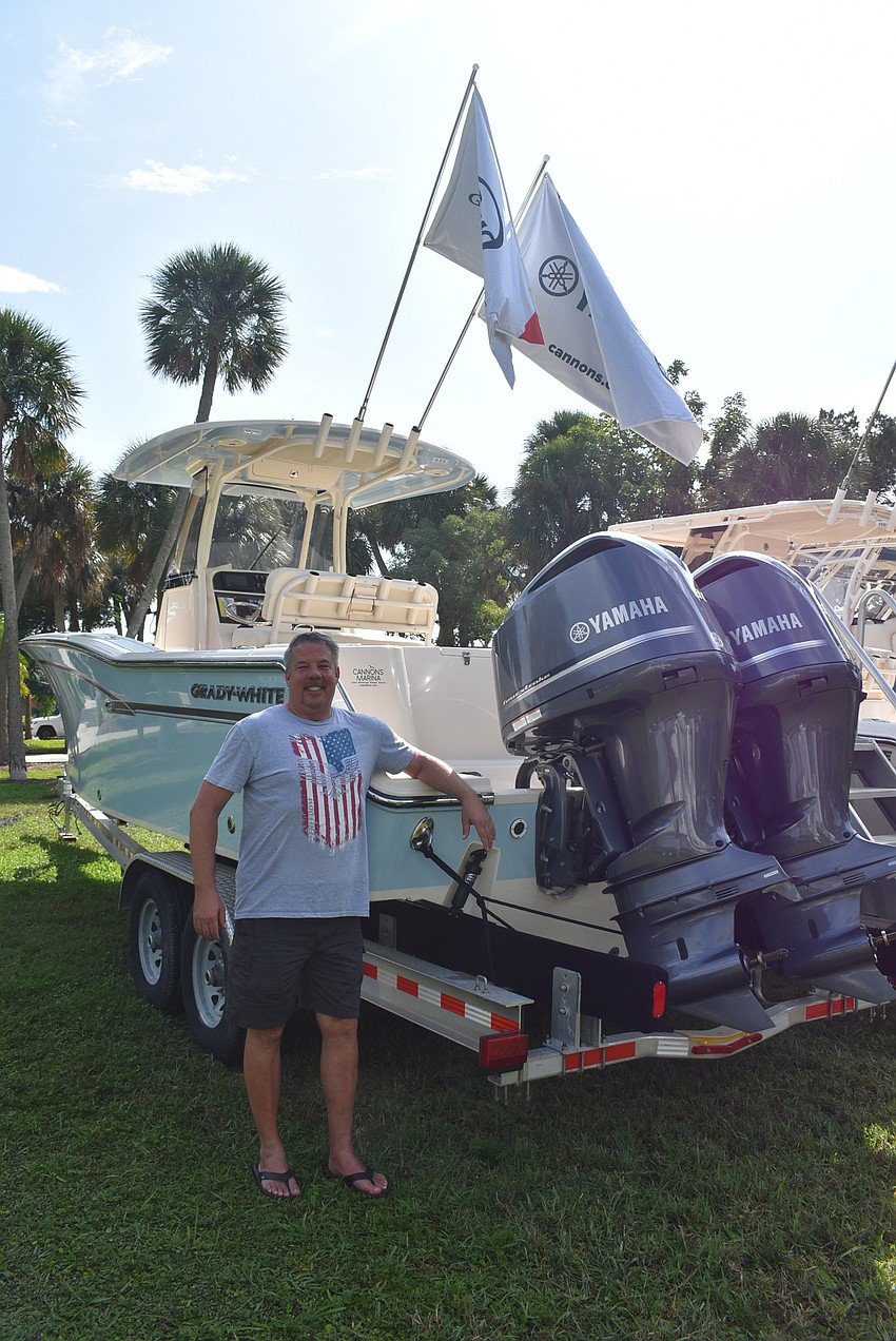 John Frazier stands in front of a boat.