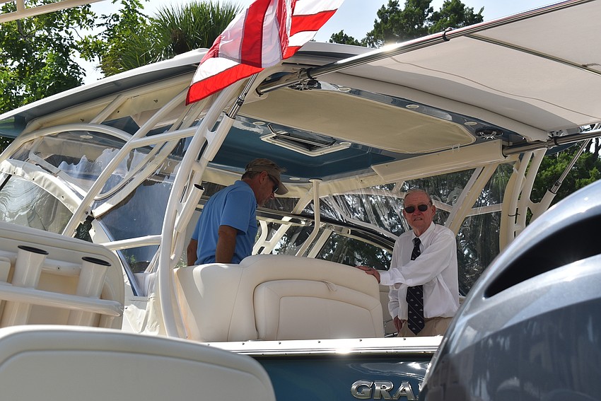 Drew White and Lawrence Bond discuss a boat.