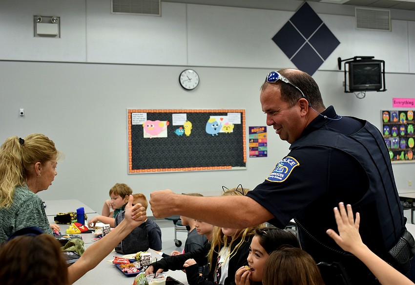 Officer Joe Reed gives out fist bumps during lunch.
