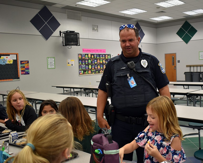 Officer Joe Reed talks with students during their lunch period.