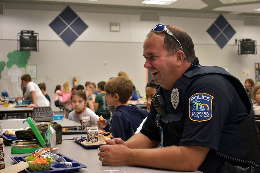 Officer Joe Reed laughs as a student tells him about his day.