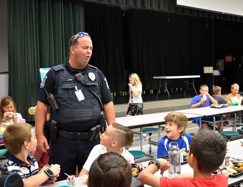 Officer Joe Reed tells a joke to students.