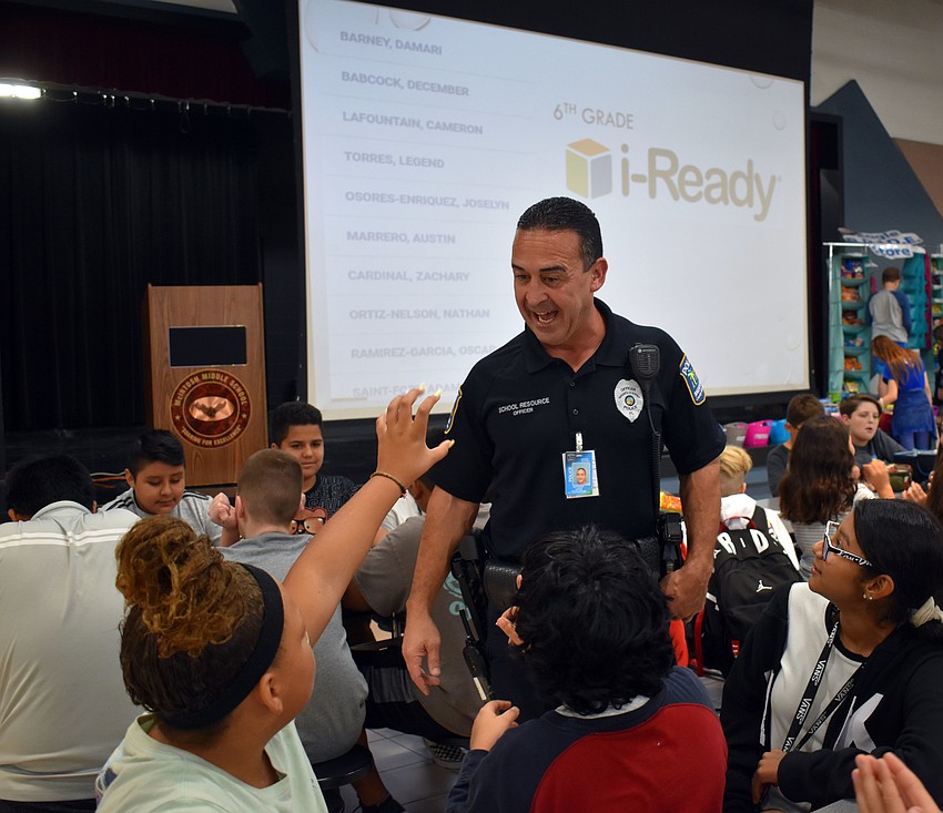 A student reaches out to high five Officer Anthony Limite.