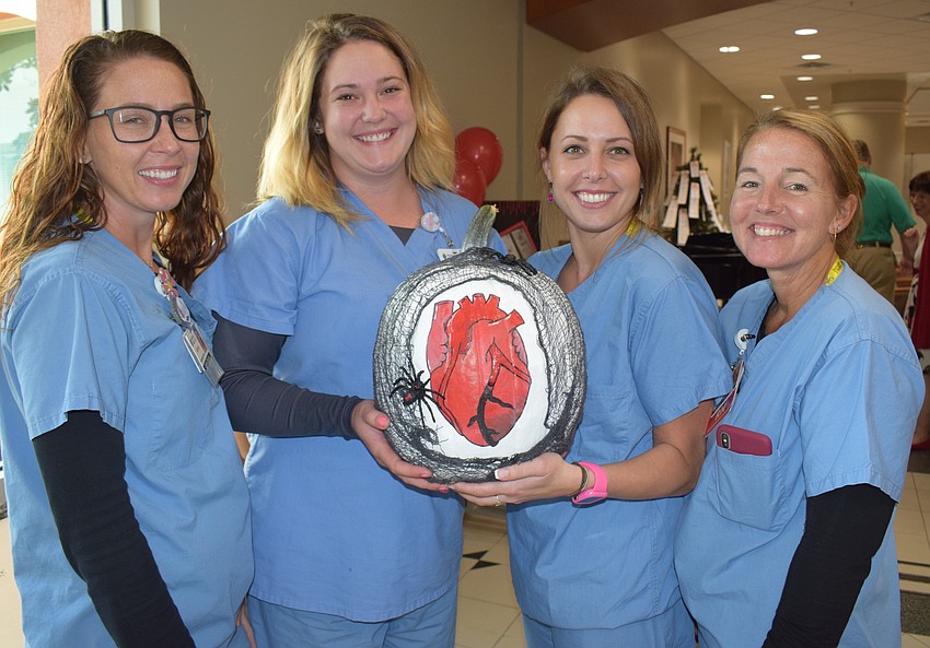 Scrub techs Ashley Warren and Katie Corso and nurses Rachel Zera and Lyn Swann presented the Widow-maker pumpkin.