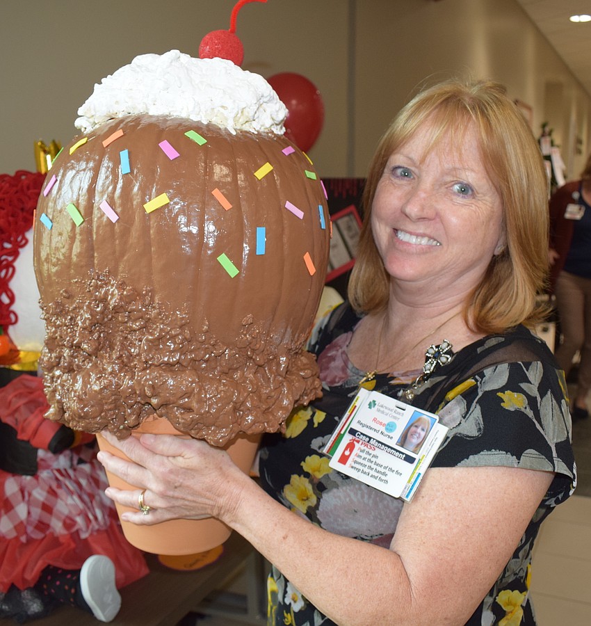 RN Case Manager Rose Mercer shows off a pumpkin that was turned into an ice cream cone. 
