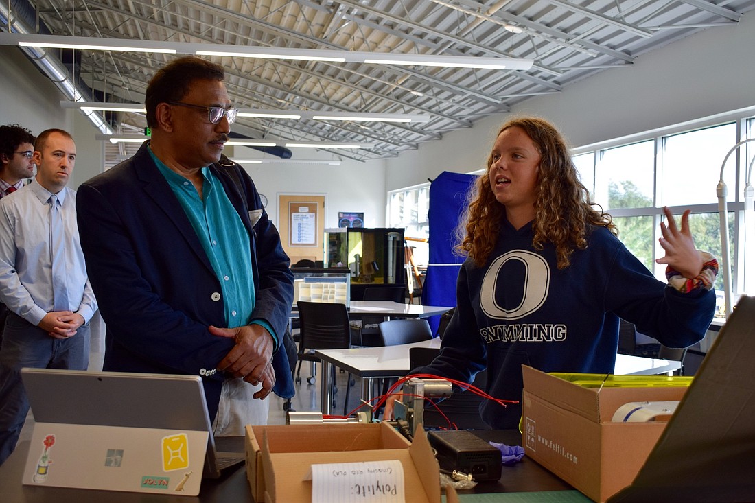 Columbia University professor Joaquim Goes listens as Out-of-Door Academy junior Reece Whatmore explains her work on creating oyster housing units.