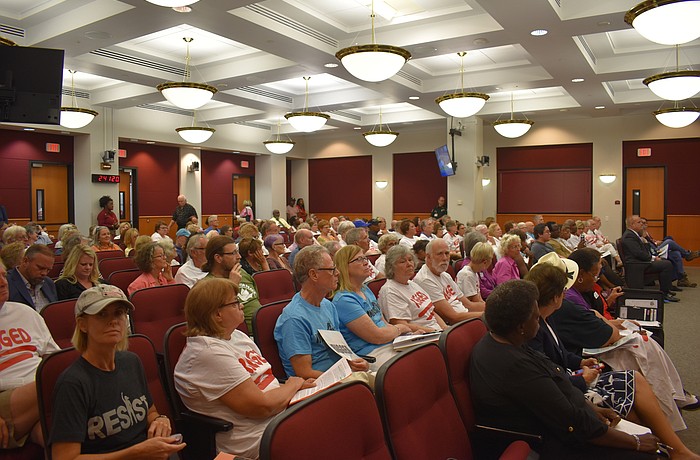 More than 100 citizens packed the commission chambers, with some wearing shirts that say "Rigged" on them.