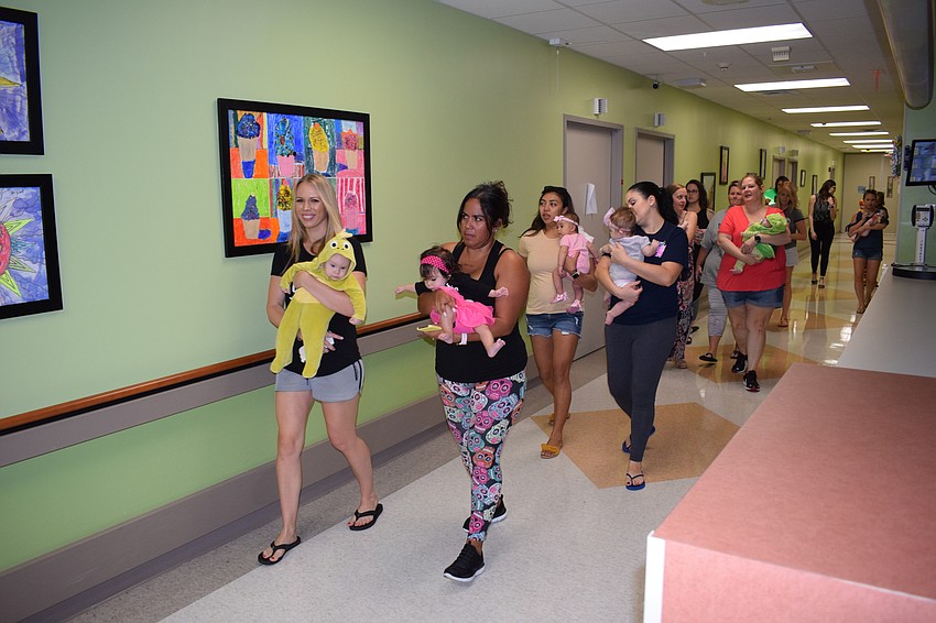 Hospital personnel cheered as the babies and their moms passed.