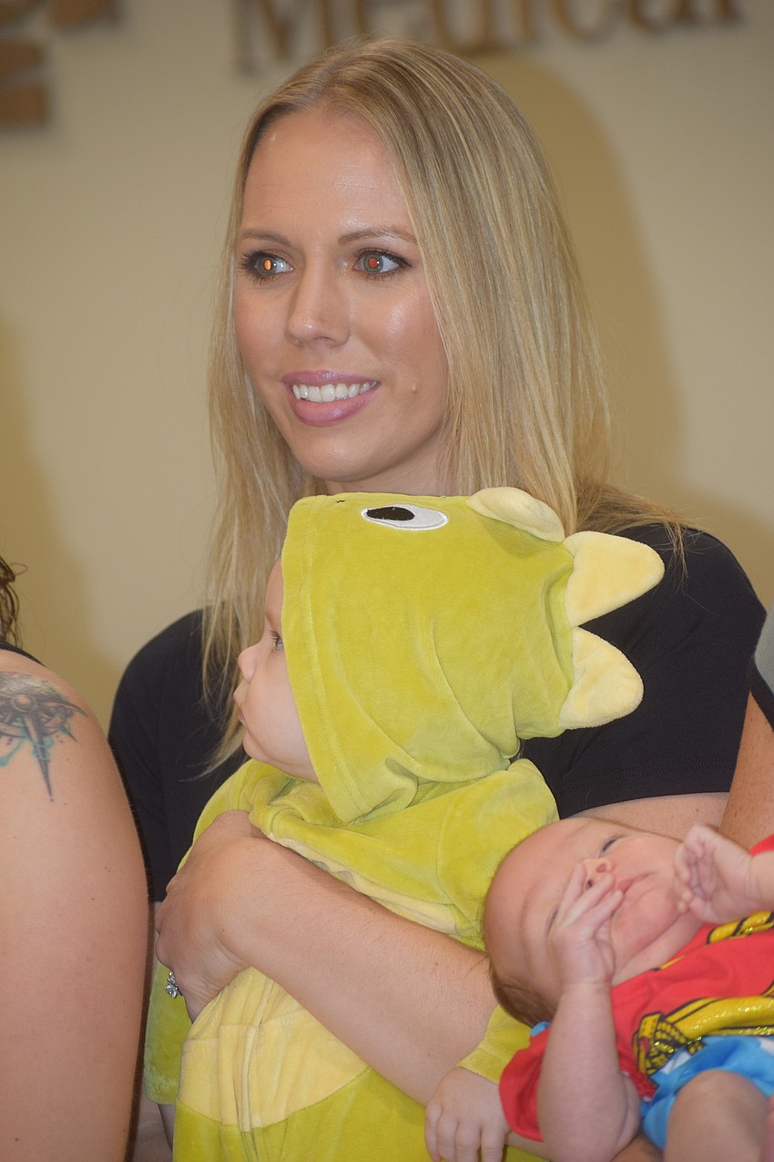 Ian Heath, who was born March 29, checks out the excitement while being carried by mom, Kaia Heath, during the parade.