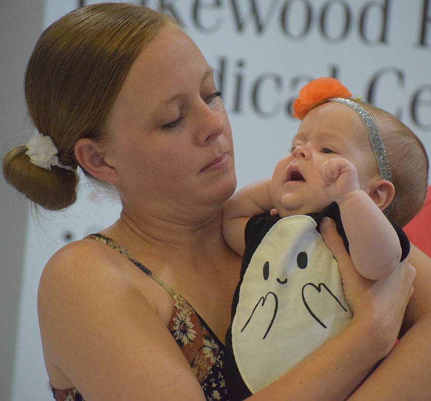 Alyssa Dolby gives her baby, Piper Dolby, a squeeze during the parade. She said giving birth at Lakewood Ranch Medical Center was a 
