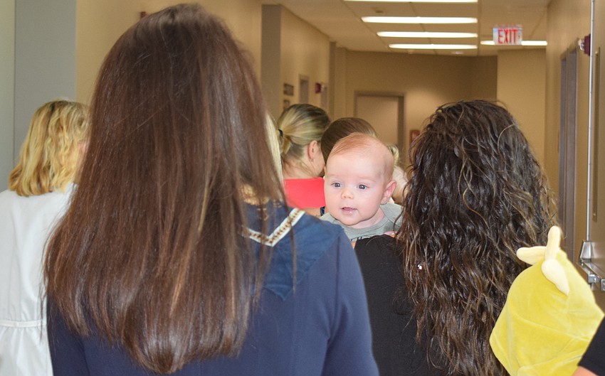 Aden DeSantis, who was born Aug. 19, makes sure no one sneaks up on mom, Michelle DeSantis, during the parade.