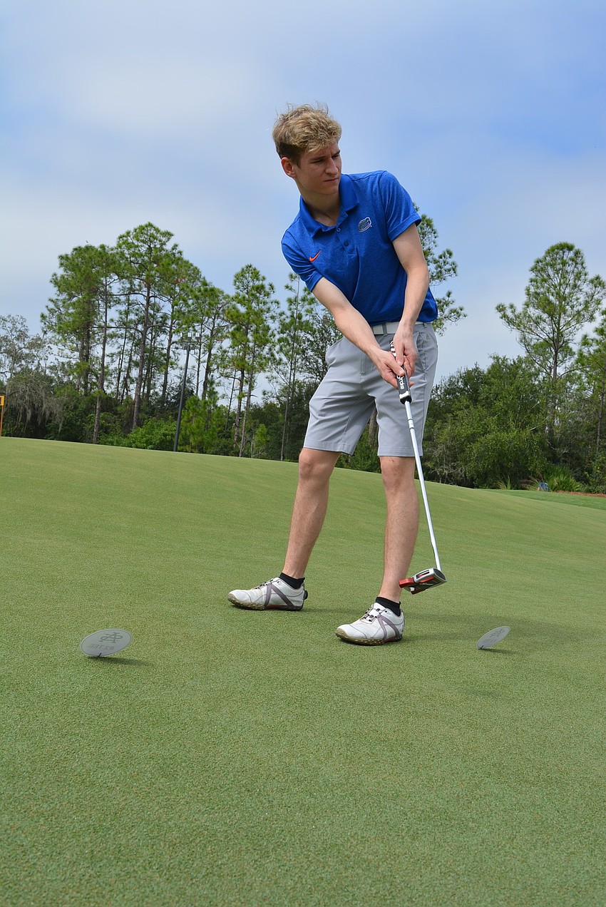 Eighteen-year-old Evan Mason tries out the putting green with his dad, Rich Mason, not pictured.