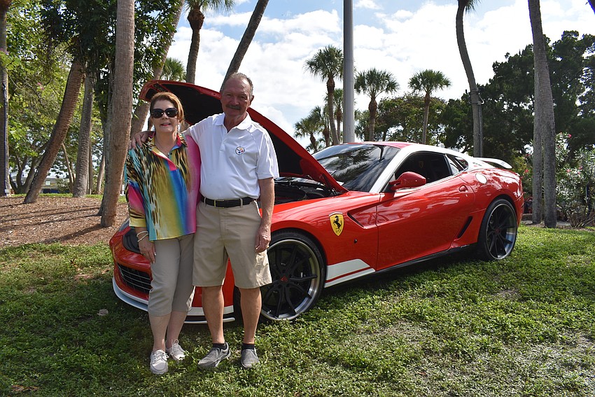 Kimberly Martino and Andrew Gentile admire the engine of one car.
