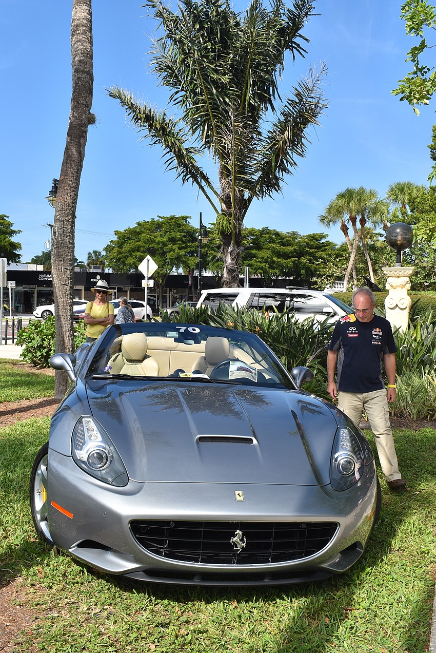 Guy Bernheim assesses a silver Ferrari.