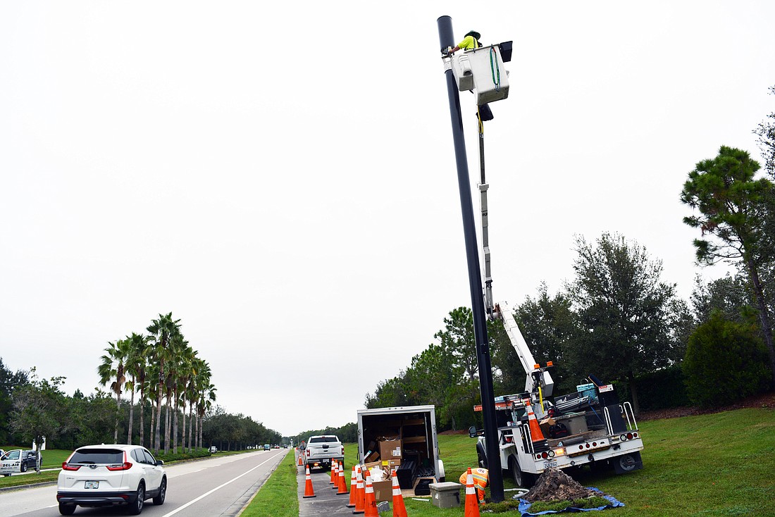 A crew from HP Communications works on installing a small cell pole  along Lakewood Ranch Boulevard at Players Drive.