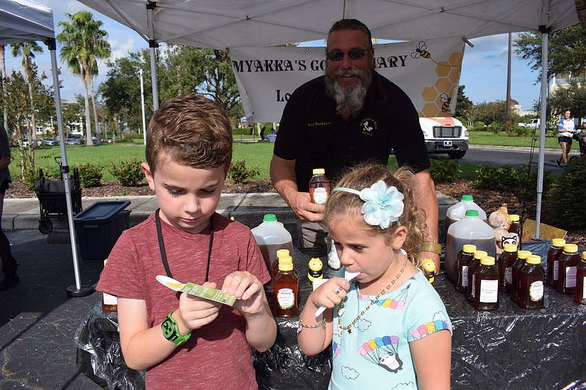 Jim Cutway watches as Ethan Quinn, 7, and Olivia Quinn, 5, enjoy his honey.