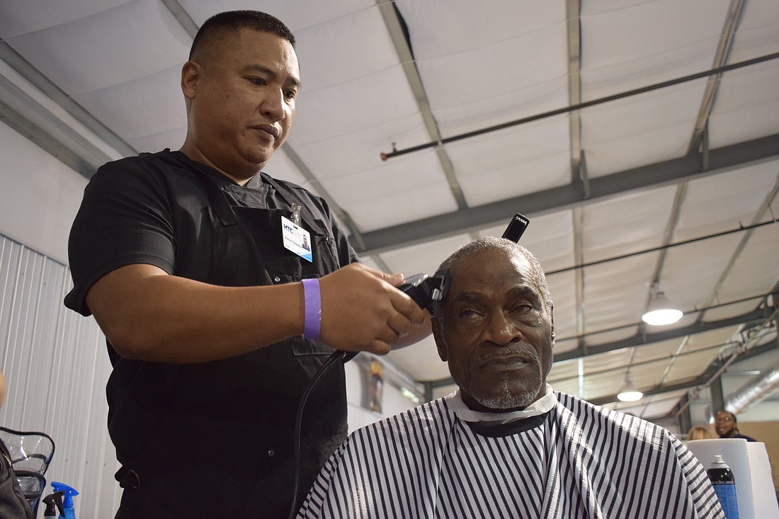 Denver Inopiquez, a Marine Corps veteran and Manatee Technical College barbering student cuts Bradenton resident Joe Brice&#39;s hair during the 21st annual Manatee County Stand Down.