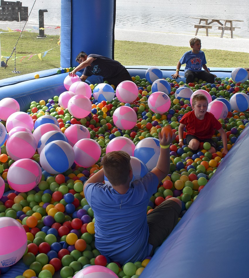 A group of kids hide from the heat in the ball pit.