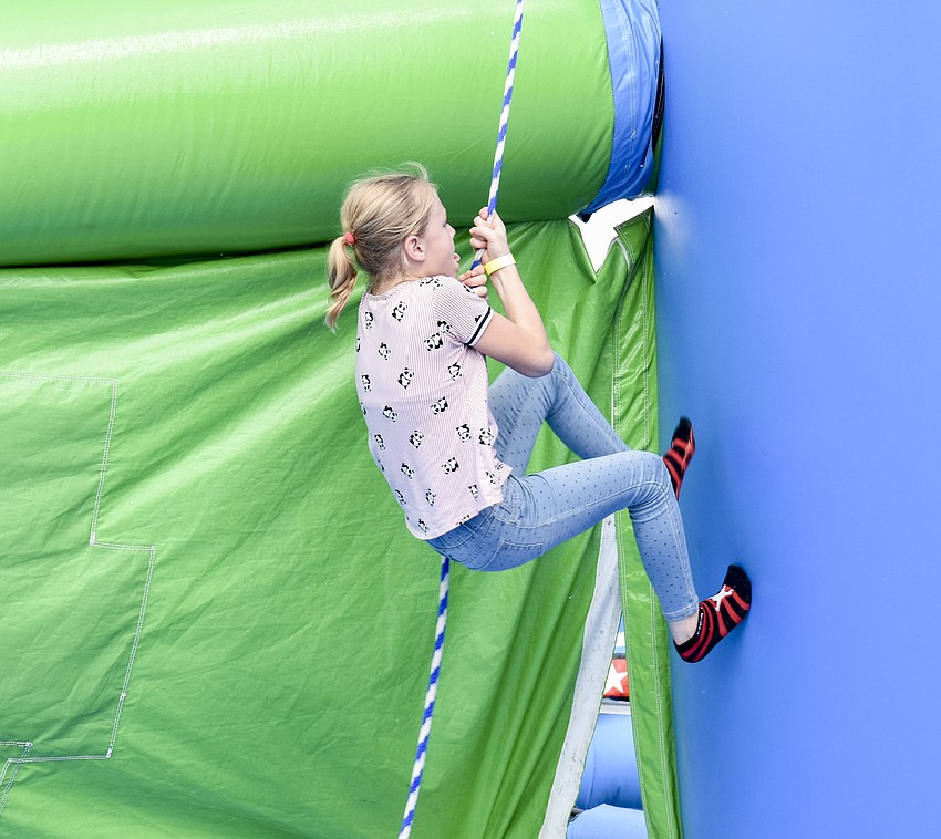 Shayla Pfolsgrof, 10, tries out the rope climb.