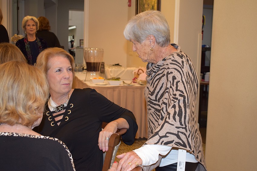 Tara residents Dyan Morgan and Barbara Loreto talk about the outfit Loreto is modeling. Morgan said the fashion show was gorgeous, and she took a coupon from the store home so she could shop at Soft Surroundings.