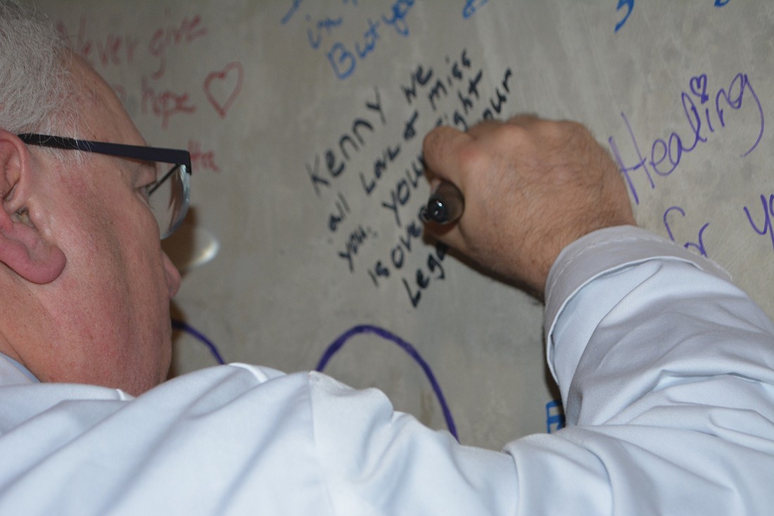 Dr. Richard Brown, Medical Director of Cancer Care Services at Sarasota Memorial Health Care System, signs the wall of the linear accelerator vault. His message was dedicated to his late cousin, Kenny Freed.