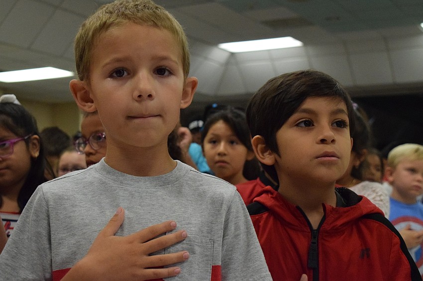 Second-graders C.J. Freeman and Mario Lopez recite the Pledge of Allegiance in unison with the rest of the school.