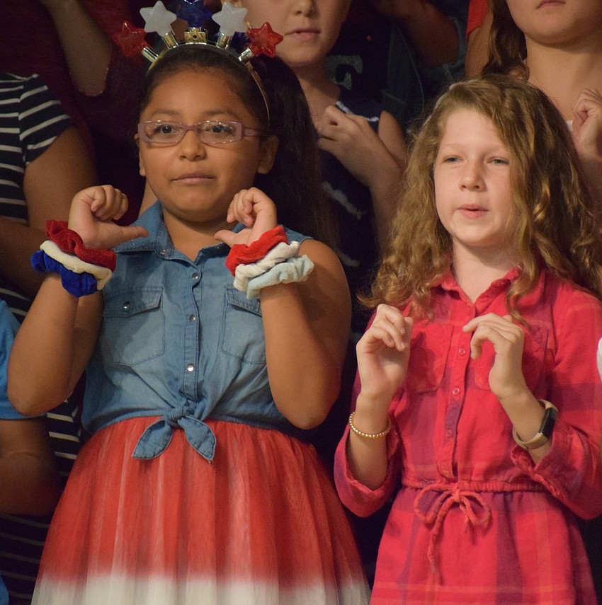 Fourth-graders Abigail Castanom and Arabella Landrum do hand movements that go along with the song 
