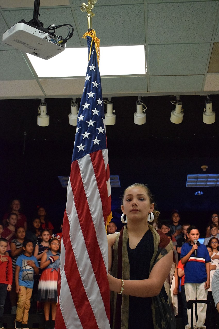 Hayden Hudson presents the American flag during the Pledge of Allegiance and National Nnthem.