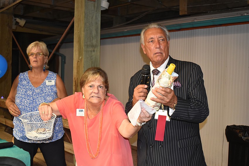 Donna Blaney, Gail Loefgren and Andrew Vac hand out door prizes.