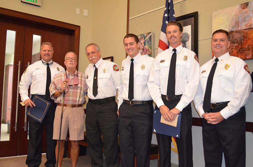 McLean, second from left, pinned Phoenix Awards to the men who saved his life: Ron Koper, Jeff Bullock, William Lewis and Jamison Urch. Standing with them is  department medical director Dr. Mike Johnson.