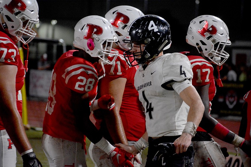 Pirates senior Robbie Goecker (4) goes through the handshake line one last time. Goecker had a touchdown in the loss.