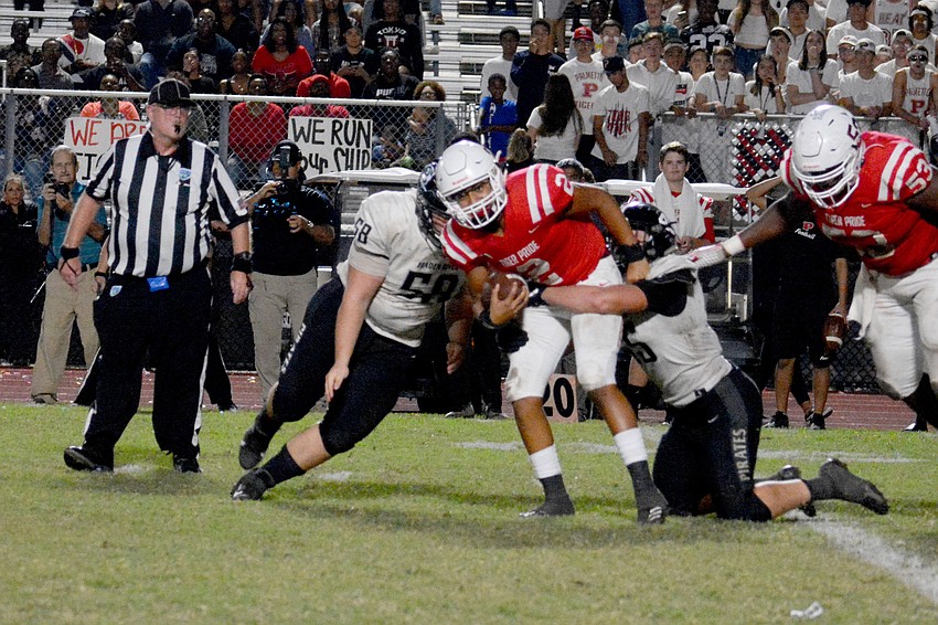 Pirates junior defensive lineman Ethan Robb (58) and senior linebacker Luke Reeves (45) take down Palmetto quarterback Xavier Williams.