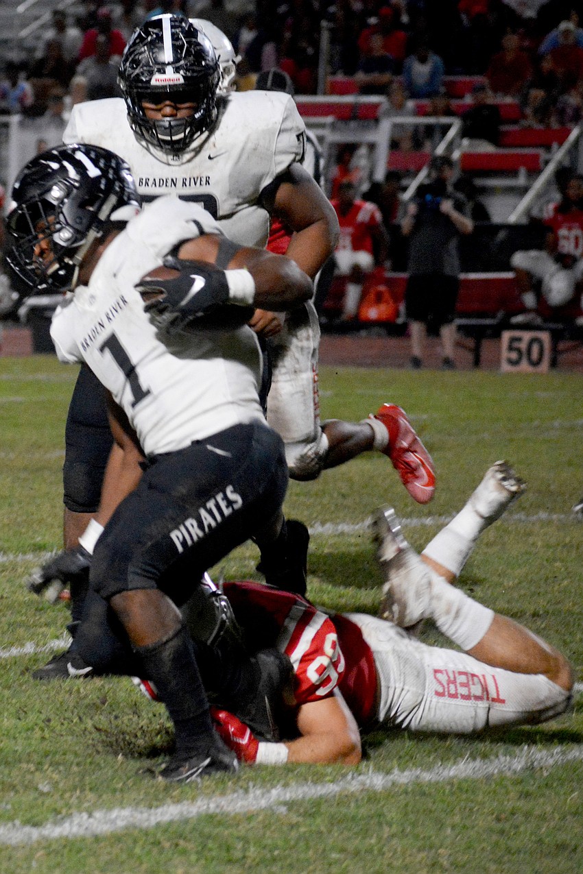 Pirates junior running back Jaheim Hodo gets tripped by a Palmetto defender.