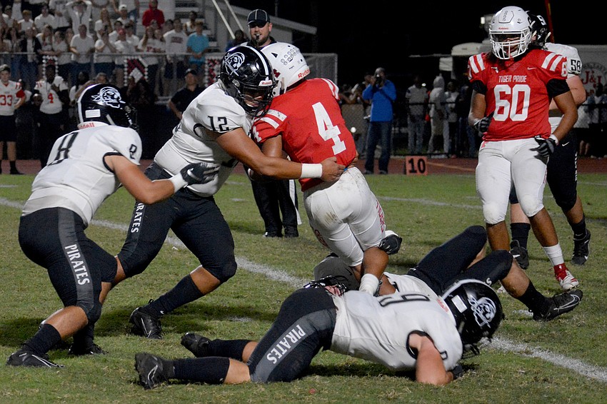 Pirates junior Anthony Toro stonewalls Palmetto junior Sagel Hickson.