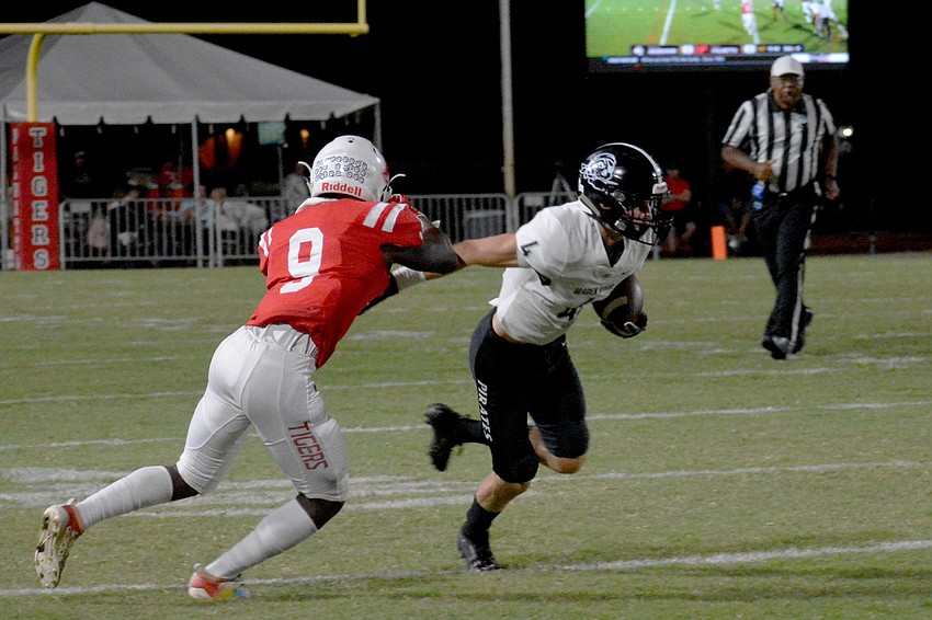 Pirates senior wideout Robbie Goecker stiff arms a Palmetto defender.